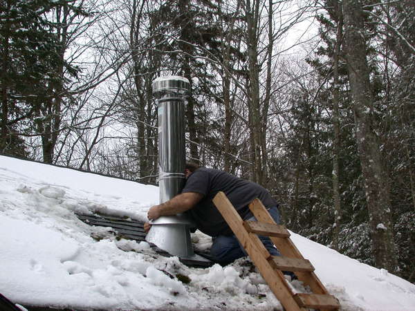 Jon putting the rain guard on the new chimney.