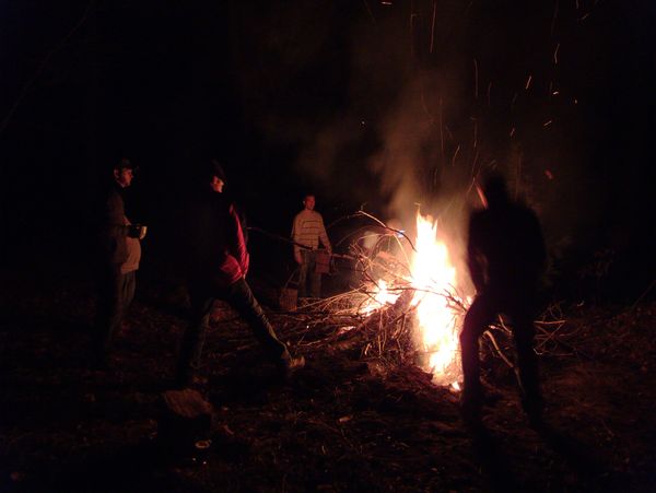 Standing around the burning stump.