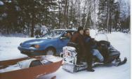 Mike in his car, Jon and Amelia on a snowmobile