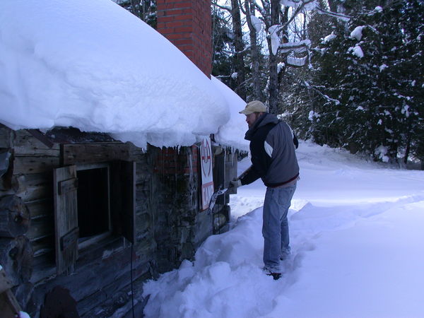 Bill knocking some of the ice dams off the cabin.