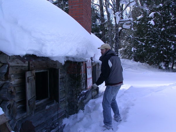 Bill knocking some ice dams off the cabin.