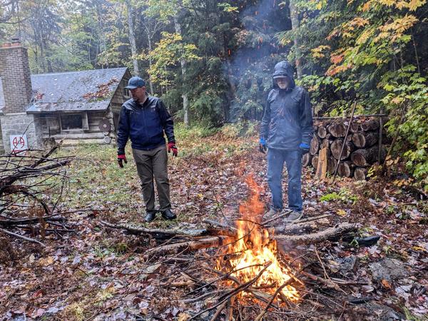Jim and Arthur watching the fire burn in the rain.
