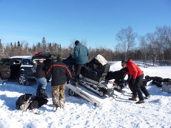 Loading the snowmobiles onto the trailer.