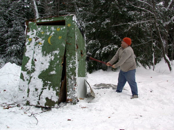 Jon putting "vent holes" in the old outhouse.