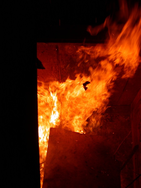 Flames spewing forth from the old outhouse.