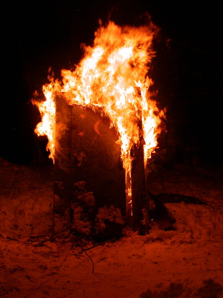 The old outhouse consumed in flames.