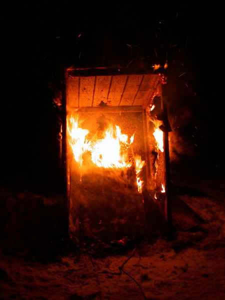 The old outhouse with the door fallen in.