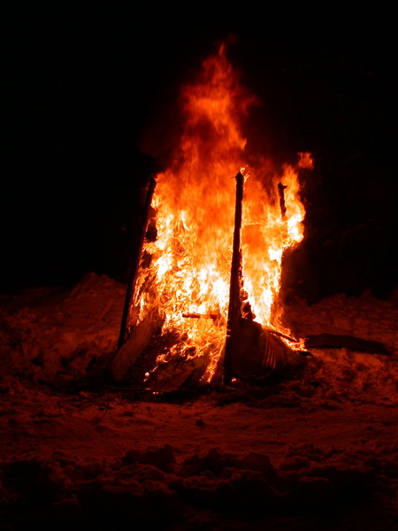 The old outhouse engulfed in flames.